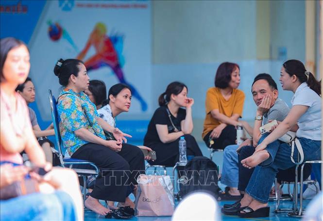Dù mưa to hay nắng gắt, các bậc phụ huynh vẫn kiên trì chờ đợi thí sinh thi bên ngoài điểm thi. Ảnh: Hoàng Hiếu - TTXVN