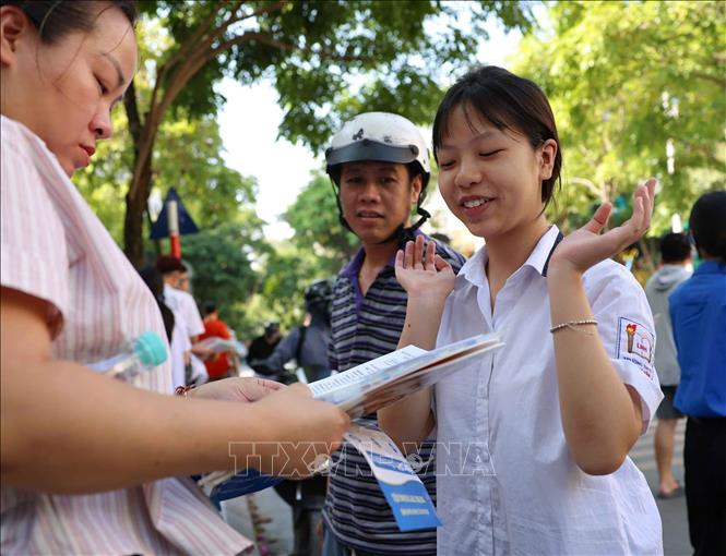 Thí sinh trao đổi về bài làm với người thân sau khi hoàn thành môn thi Ngoại ngữ tại điểm thi Trường THCS Lê Ngọc Hân. Ảnh: Thanh Tùng - TTXVN