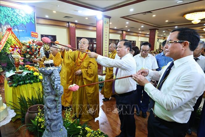 Các đại biểu và Phật tử thực hiện nghi thức tắm Phật. Ảnh: Minh Đức - TTXVN