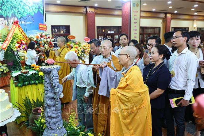 Các đại biểu và Phật tử thực hiện nghi thức tắm Phật. Ảnh: Minh Đức - TTXVN