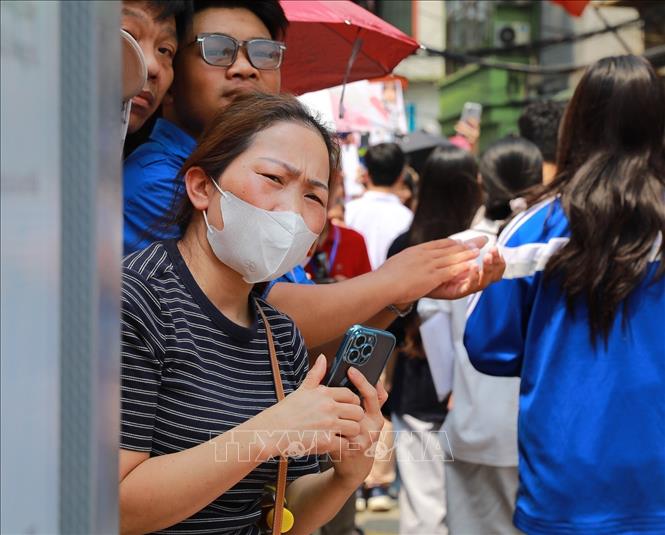 Tâm trạng hồi hộp, mong ngóng của phụ huynh chờ con thi. Ảnh: Khánh Hoà - TTXVN