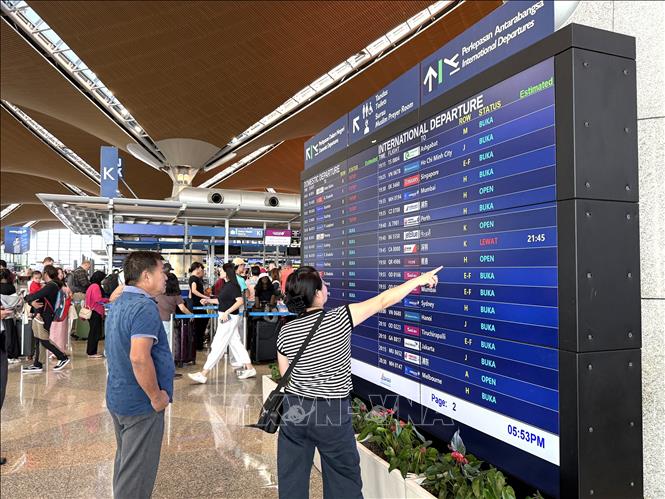Hành khách đang theo dõi lịch trình các chuyến bay tại Sân bay Quốc tế Kuala Lumpur, Malaysia. Ảnh: Bình Thanh - PV TTXVN tại Malaysia