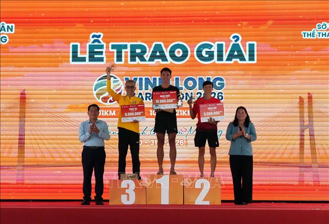 Ban tổ chức trao giải Nhất, Nhì, Ba cho các vận động viên ở nội dung nam cự ly 42 km. Ảnh: Phạm Minh Tuấn-TTXVN.