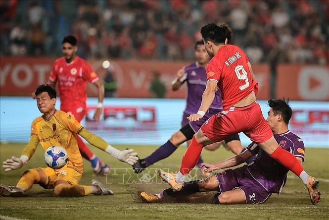 Nguyễn Đình Bắc băng vào dứt điểm trong vòng cấm, trước sự truy cản quyết liệt của hậu vệ và thủ môn Becamex. Ảnh: Phạm Tuấn Anh - TTXVN