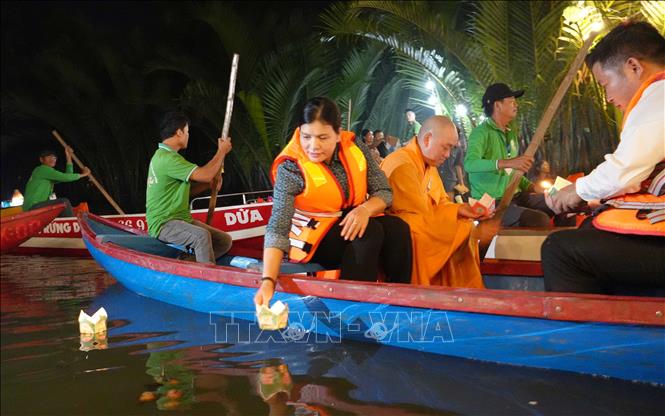 Các đại biểu tham dự thả hoa đăng trên sông Kinh. Ảnh: Dư Toán - TTXVN