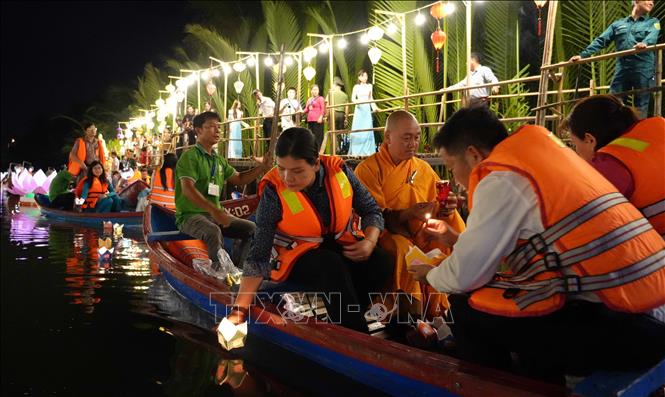 Các đại biểu tham dự thả hoa đăng trên sông Kinh. Ảnh: Dư Toán - TTXVN