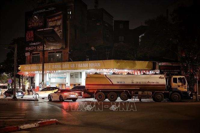 Tối 31/5, tại cửa hàng bán lẻ xăng dầu 48 Thanh Nhàn, nhiều phương tiện vẫn tranh thủ vào đổ xăng RON95 trước thời điểm chuyển đổi sang xăng E10. Theo chia sẻ của quản lý cửa hàng, đúng 0h ngày 1/6/2026, đơn vị sẽ bắt đầu chuyển sang bán xăng E10; xe bồn đã túc trực chờ nhập nhiên liệu mới sau khi bán nốt lượng xăng còn lại trong ngày. Ảnh: Phạm Tuấn Anh - TTXVN