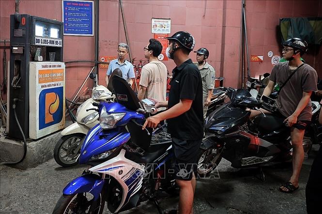 Nhiều người tranh thủ đổ đầy bình cho ô tô, xe máy trước thời điểm thay đổi chủng loại xăng trên thị trường. Ảnh: Phạm Tuấn Anh - TTXVN