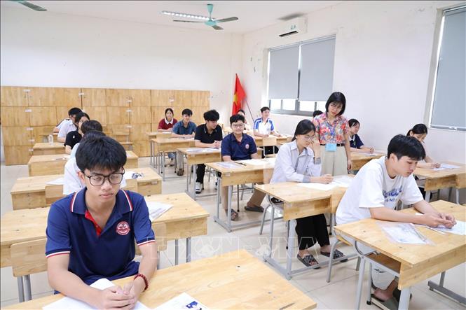Giám thị tại điểm thi Trường THPT Chuyên Vĩnh Phúc hướng dẫn học sinh làm thủ tục dự thi. Ảnh: Nguyễn Thảo - TTXVN