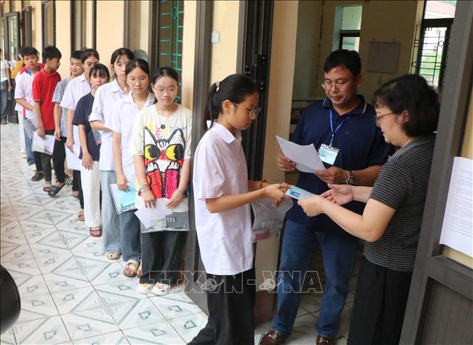 Giám thị gọi tên thí sinh vào phòng thi tại điểm thi Trường THPT Hùng Vương (phường Phú Thọ). Ảnh: Thu Hương – TTXVN