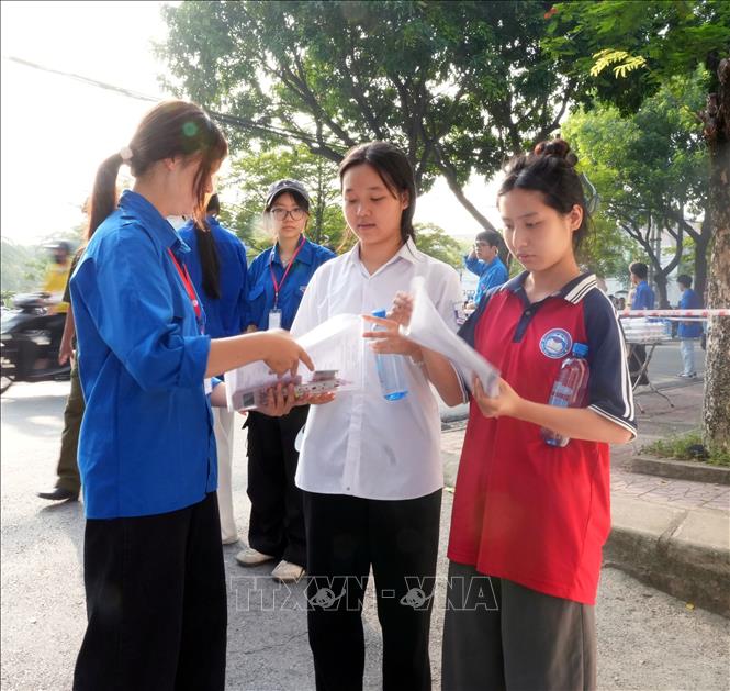 Thí sinh tại Hội đồng coi thi Trường THPT Vĩnh Yên được thanh niên tình nguyện hướng dẫn, kiểm tra giấy tờ cần thiết trước khi vào phòng thi. Ảnh: Nguyễn Thảo - TTXVN