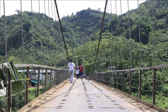 Do việc di chuyển bằng đường khác mất rất nhiều thời gian nên học sinh vẫn hàng ngày đi bộ qua cầu treo Yên Phú. Ảnh: Đinh Thùy - TTXVN