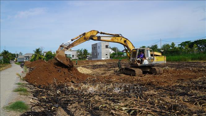 Máy móc đắp bờ bao để bơm cát san lấp mặt bằng, thi công Dự án trường Phổ thông nội trú Tiểu học - THCS Thường Phước. Ảnh: Nhựt An - TTXVN                               