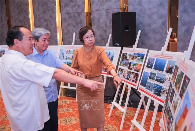 Các thành viên Hội đồng thảo luận về tác phẩm ảnh báo chí được lựa chọn vào Chung khảo. Ảnh: Hoàng Hiếu - TTXVN