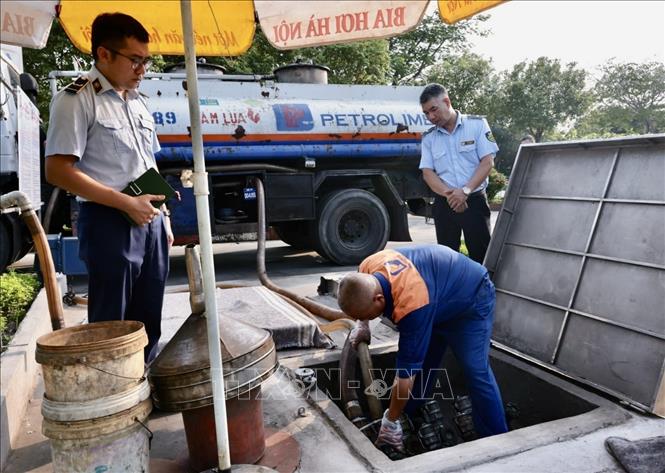 Cán bộ Đội QLTT số 16 kiểm tra cửa hàng kinh doanh xăng dầu số 84, Phúc Lợi, Hà Nội. Ảnh: Trần Việt - TTXVN