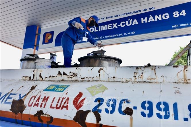 Lấy mẫu xăng dầu trước khi nhập bán. Ảnh: Trần Việt - TTXVN 