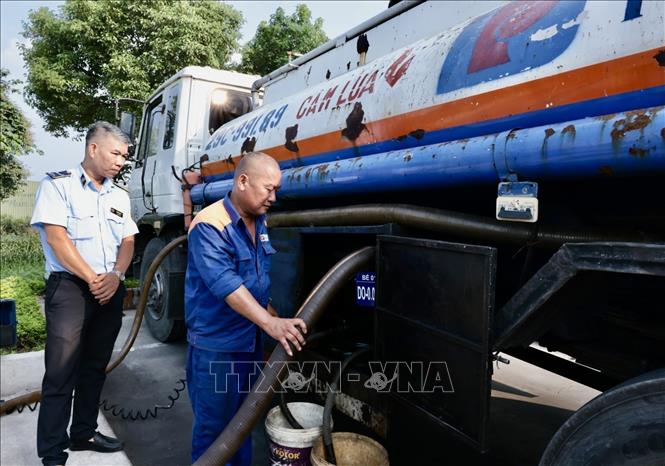Cán bộ Đội QLTT số 16 kiểm tra cửa hàng kinh doanh xăng dầu số 84, Phúc Lợi, Hà Nội. Ảnh: Trần Việt - TTXVN