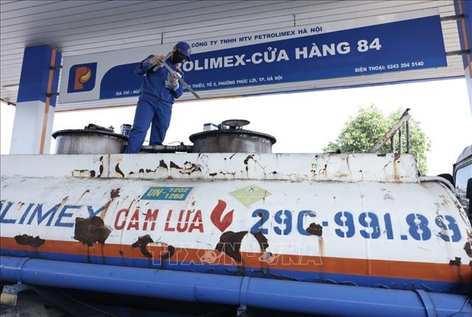 Lấy mẫu xăng dầu trước khi nhập bán. Ảnh: Trần Việt - TTXVN 