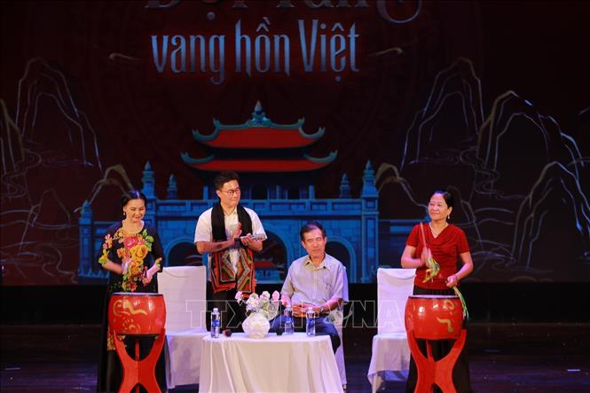 Trò truyện với các nghệ nhân về lịch sử của làng nghề trống Đọi Tam. Ảnh: Khánh Hoà - TTXVN