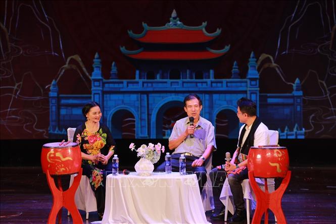 Trò truyện với các nghệ nhân về lịch sử của làng nghề trống Đọi Tam. Ảnh: Khánh Hoà - TTXVN