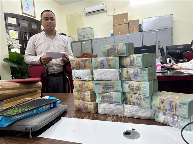 Lượng lớn tiền mặt cùng nhiều tang vật bị lực lượng chức năng thu giữ. Ảnh: TTXVN phát