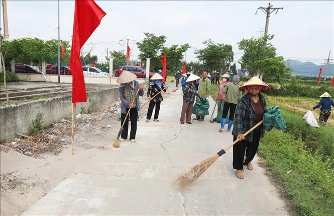 Cán bộ, hội viên Hội nông dân phường Yên Dũng tham gia quét dọn, thu gom rác thải, bảo vệ môi trường tại buổi lễ. Ảnh: Việt Hùng – TTXVN