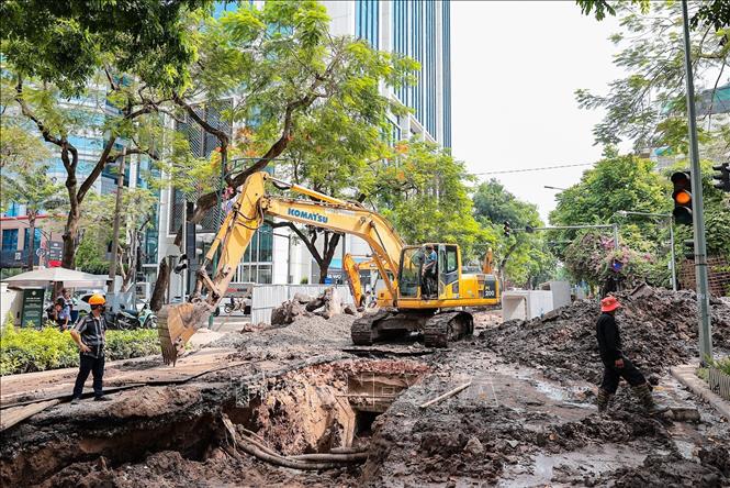 Đơn vị thi công tập trung nhân lực, thiết bị đẩy nhanh tiến độ đào mở và lắp đặt tuyến cống ngầm mới trên phố Quang Trung. Ảnh: Lê Đông - TTXVN