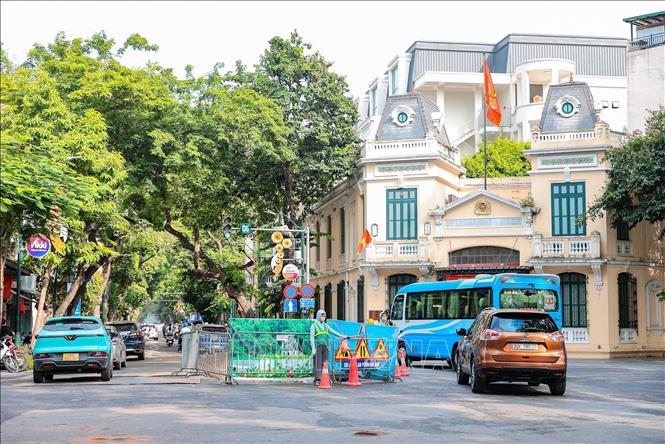 Đơn vị thi công bố trí nhân viên phân luồng giao thông tại khu vực ngã 4 Hàng Khay - Tràng Thi, nhằm bảo đảm an toàn cho người và phương tiện trong thời gian thi công hệ thống cống ngầm. Ảnh: Lê Đông - TTXVN
