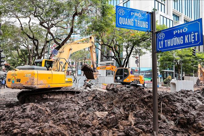 Công nhân và máy móc được huy động thi công hạng mục cống ngầm trên góc phố Quang Trung - Lý Thường Kiệt nhằm nâng cao năng lực tiêu thoát nước khu vực trung tâm Hà Nội. Ảnh: Lê Đông - TTXVN