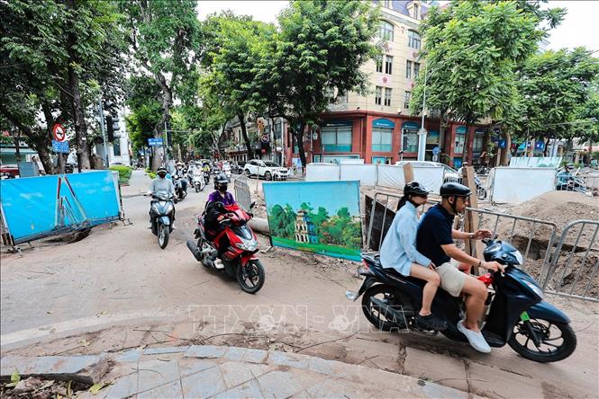 Các phương tiện tham gia giao thông qua ngã tư Tràng Thi - Quang Trung di chuyển khó khăn trong thời gian triển khai dự án xây dựng hệ thống cống ngầm. Ảnh: Lê Đông - TTXVN