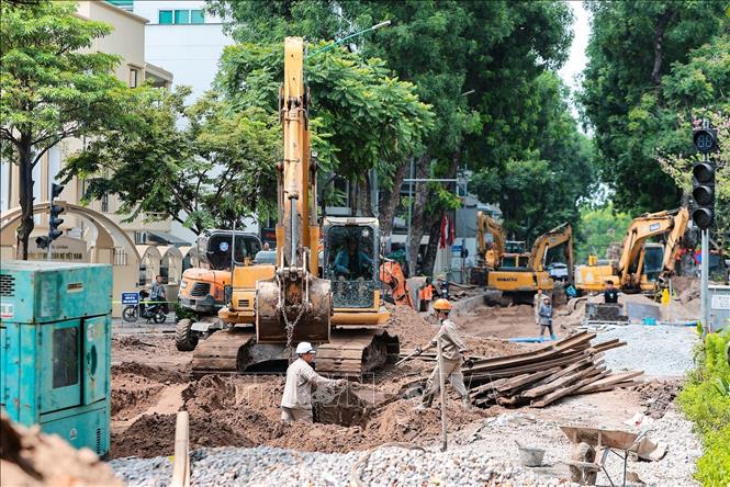 Đơn vị thi công tập trung nhân lực, thiết bị đẩy nhanh tiến độ đào mở và lắp đặt tuyến cống ngầm mới trên phố Quang Trung gần công viên Thống Nhất. Ảnh: Lê Đông - TTXVN