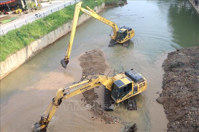 Nhà thầu huy động máy móc nạo vét, thanh thải lòng sông Hiến . Ảnh: Chu Hiệu - TTXVN