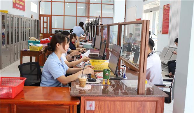 Tại Trung tâm Phục vụ hành chính công xã Nha Bích, người dân đến giao dịch được hướng dẫn tận tình, nhiều thủ tục được giải quyết ngay tại cơ sở mà không phải qua cấp trung gian như trước. Ảnh: Đậu Tất Thành – TTXVN