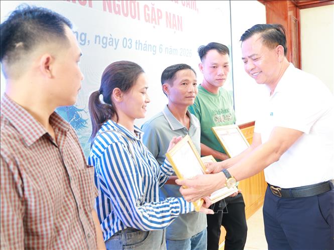 Lãnh đạo xã Phú Riềng khen thưởng cho cá nhân đã kịp thời cứu người do lũ. Ảnh: TTXVN phát