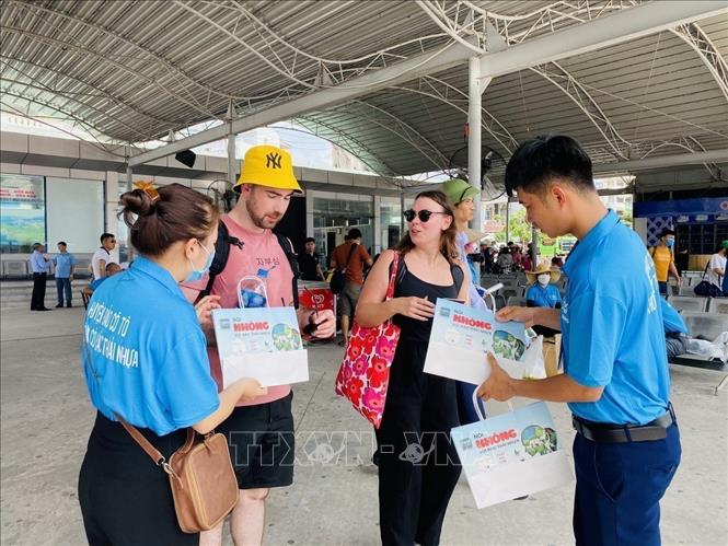Du khách nước ngoài rất ủng hộ việc làm của huyện đảo Cô Tô (Quảng Ninh), vui vẻ thay đổi túi nilon sang túi giấy. Ảnh: Thanh Vân - TTXVN