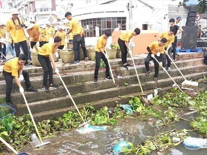 Sinh viên tham gia Chiến dịch “Làm sạch sông Mê Kông” tiến hành thu gom rác dọc theo bờ sông, nhằm chống lại tình trạng ô nhiễm nước do chất thải trôi nổi trên sông Mê Kông. Ảnh: Lê Thúy Hằng - TTXVN