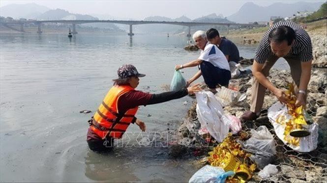 Người dân thành phố Hòa Bình, tỉnh Hòa Bình đi thu gom túi nylon vứt xuống sông Đà trong ngày Tết Táo quân để bảo vệ môi trường. Ảnh: Thanh Hải - TTXVN