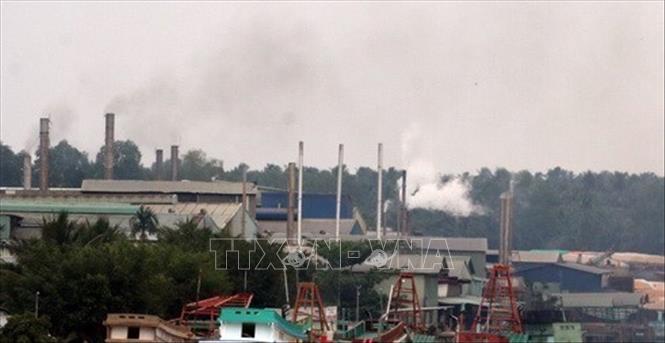 Các ống khói thải mù mịt ra từ các nhà máy bột cá nằm dọc sông Cái Bé, tỉnh Kiên Giang, gây ô nhiễm môi trường không khí. Ảnh: Lê Sen -TTXVN