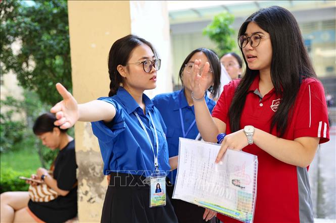 Tình nguyện viên hướng dẫn thí sinh tham dự kỳ thi. Ảnh: Thanh Tùng - TTXVN