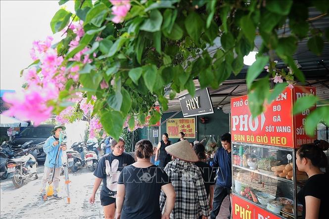 Công tác đo đạc, kiểm đếm diễn ra xen giữa nhịp sinh hoạt thường ngày của các hộ kinh doanh của tổ 75, phường Kim Liên. Ảnh: Phạm Tuấn Anh - TTXVN