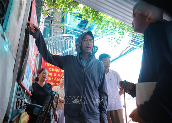 Cán bộ phường Kim Liên hướng dẫn người dân xác định mốc ranh giới. Ảnh: Hoàng Hiếu - TTXVN