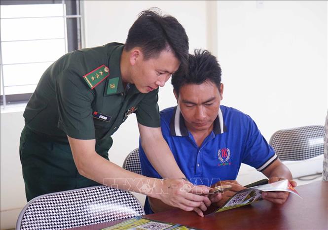 Cán bộ Đồn biên phòng Bình Nghi, tỉnh Lạng Sơn hướng dẫn người dân gửi thông tin tố giác qua mã QR Hòm thư ẩn danh. Ảnh: Quang Duy – TTXVN