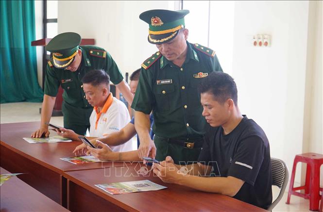 Cán bộ Đồn biên phòng Bình Nghi, tỉnh Lạng Sơn hướng dẫn người dân gửi thông tin tố giác qua mã QR Hòm thư ẩn danh. Ảnh: Quang Duy – TTXVN