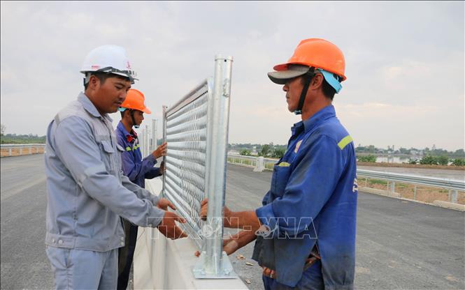 Công nhân lắp đặt hệ thống an toàn giao thông tại gói thầu 44, tuyến cao tốc Châu Đốc - Cần Thơ - Sóc Trăng, đoạn qua xã Vĩnh Hanh, tỉnh An Giang. Ảnh: Công Mạo-TTXVN