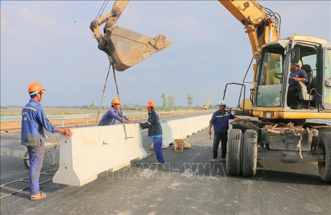 Công nhân lắp đặt dải phân cách tại gói thầu 44, tuyến cao tốc Châu Đốc - Cần Thơ - Sóc Trăng, đoạn qua xã Vĩnh Hanh, tỉnh An Giang. Ảnh: Công Mạo-TTXVN
