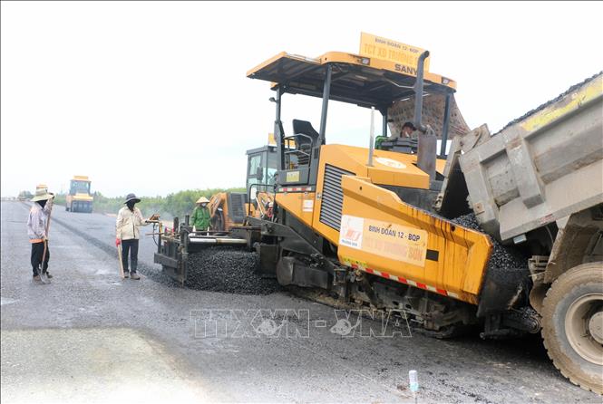 Công nhân thảm nhựa tại gói thầu 42, tuyến cao tốc Châu Đốc - Cần Thơ - Sóc Trăng, đoạn qua phường Vĩnh Tế, tỉnh An Giang. Ảnh: Công Mạo-TTXVN

