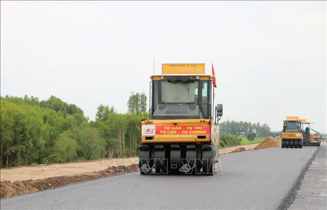 Công nhân thảm nhựa tại gói thầu 42, tuyến cao tốc Châu Đốc - Cần Thơ - Sóc Trăng, đoạn qua phường Vĩnh Tế, tỉnh An Giang. Ảnh: Công Mạo - TTXVN