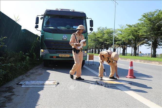 Tổ công tác của Đội Cảnh sát giao thông đường bộ số 10, Phòng Cảnh sát giao thông triển khai tuần tra, kiểm soát tải trọng trên Quốc lộ 21C. Ảnh: Quốc Lũy - TTXVN