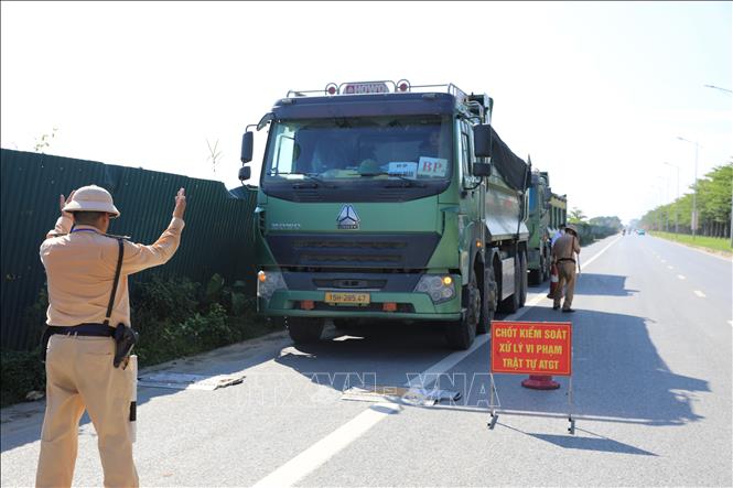 Tổ công tác của Đội Cảnh sát giao thông đường bộ số 10, Phòng Cảnh sát giao thông hướng dẫn lái xe vào khu vực kiểm tra tải trọng xe. Ảnh: Quốc Lũy - TTXVN
