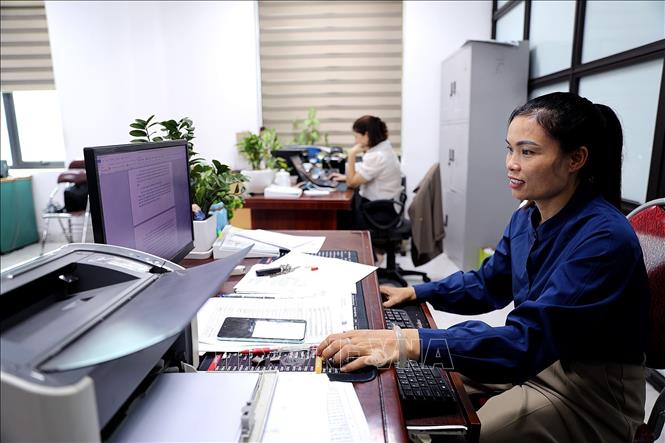 Cán bộ UBND phường Hòa Bình nỗ lực làm việc từ 12 đến 14 giờ mỗi ngày để bảo đảm tiến độ giải quyết công việc. Ảnh: Thanh Hải - TTXVN 
